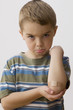 Pouting Caucasian boy with bandage on elbow