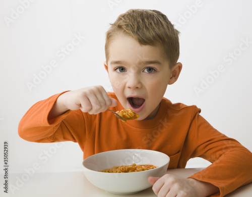 Foto: Caucasian boy eating from bowl Caucasian boy eating from bowl