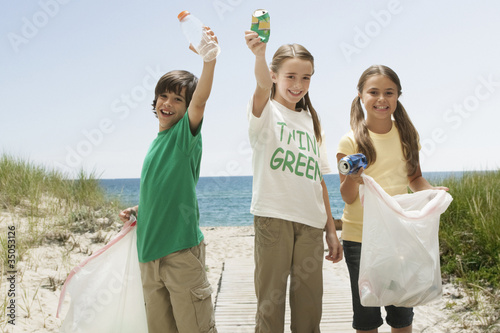 Foto: Caucasian children picking up litter from beach Caucasian children picking up litter from beach