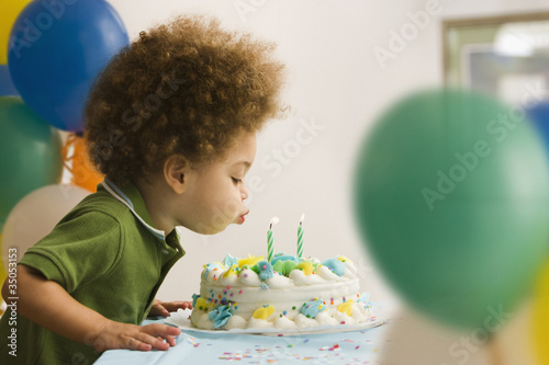 Photo: Mixed race boy blowing out birthday candles Mixed race boy blowing out birthday candles