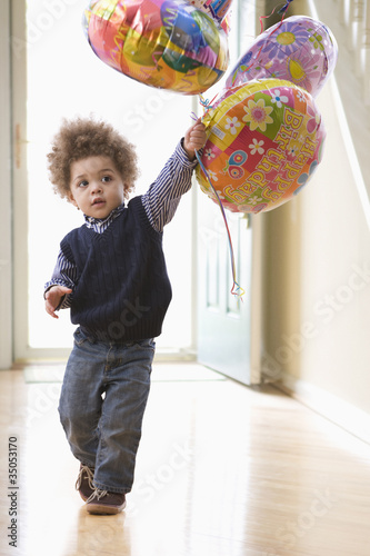 Photo: Mixed race boy holding birthday balloons Mixed race boy holding birthday balloons