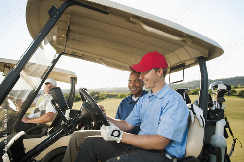 Photo: Men driving golf carts on golf course Men driving golf carts on golf course