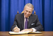 Hispanic politician signing book at desk
