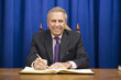 Hispanic politician signing book at desk