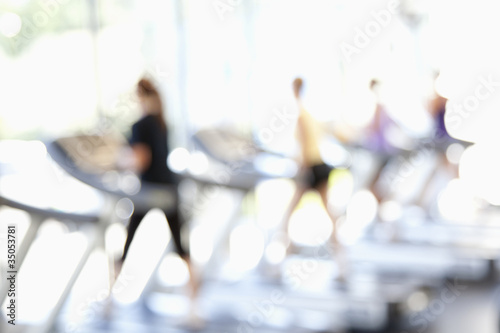 Photo: Defocused view of people on treadmills in health club Defocused view of people on treadmills in health club