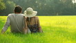 Couple sitting on meadow and looking at the landscape