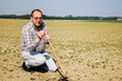 Bauer auf Feld mit kleinen Pflanzen