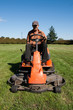 Mature man driving grass cutter