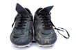 Dirty black leather football soccer boots isolated on white