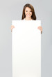 Businesswoman showing signboard, over grey