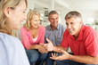 Photo: Mid age couples chatting at home Mid age couples chatting at home
