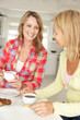 Mid age women chatting over coffee at home