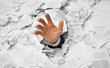 Hand reaches out from crumpled papers