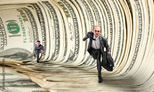 Photo: Businessmen running in dollar tunnel Businessmen running in dollar tunnel