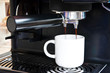 A white cup of freshly brewed strong coffee pouring A white cup of freshly brewed strong coffee pouring