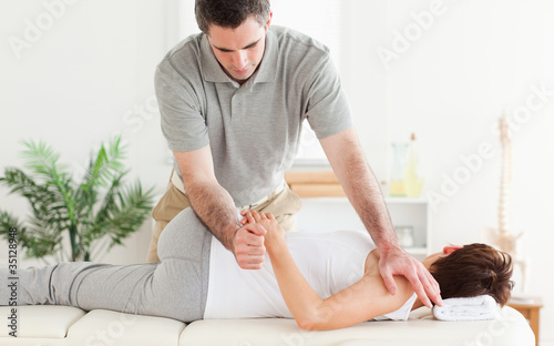 Foto: Masseur stretching woman's arm Masseur stretching woman's arm