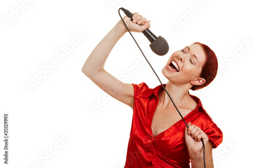 Foto: Frau singt Karaoke mit Mikrofon Frau singt Karaoke mit Mikrofon