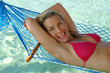 Junge Frau im Urlaub auf der Luftmatratze