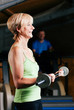 Foto: Ältere Frau macht Sport mit Langhantel im Fitnessstudio Ältere Frau macht Sport mit Langhantel im Fitnessstudio