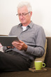 Photo: Senior working on a tablet pc Senior working on a tablet pc