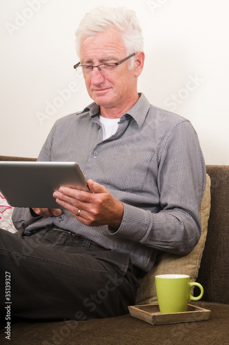Photo: Senior working on a tablet pc Senior working on a tablet pc
