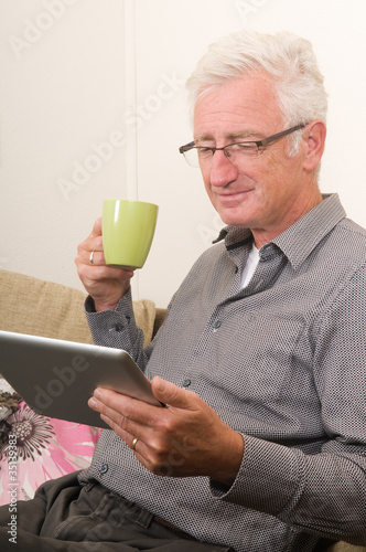 Photo: Senior working on a tablet pc Senior working on a tablet pc