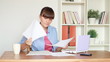 Woman calculating her bills by the table at home
