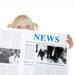 Cute blond child is reading newspaper