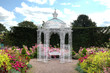 White wrought iron arbour in an English garden White wrought iron arbour in an English garden