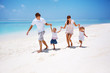 Young family running on the beach Young family running on the beach