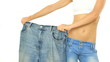 Video: Slim woman showing her old big jeans, isolated on white Slim woman showing her old big jeans, isolated on white