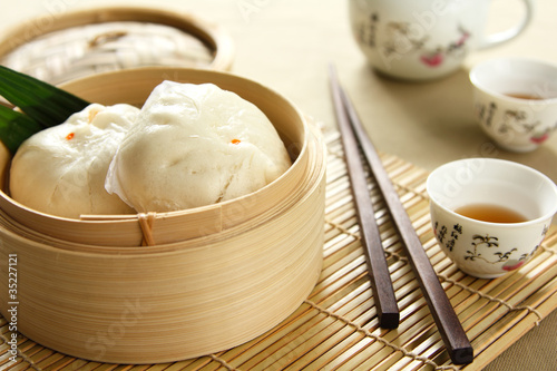 Photo: Dimsum in a bamboo basket by tea pot and cups Dimsum in a bamboo basket by tea pot and cups