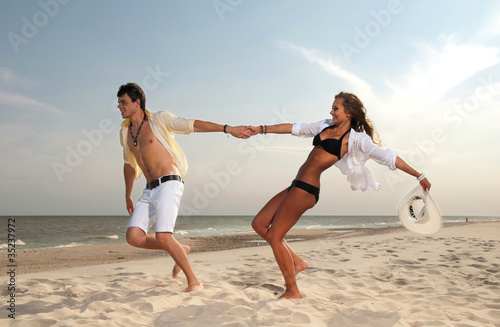 Photo: boy and girl running on beach boy and girl running on beach