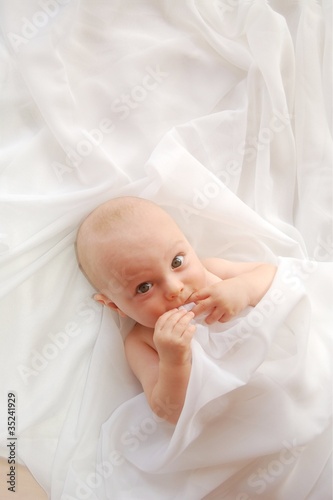 Photo: Cute baby on a white blanket Cute baby on a white blanket