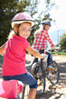 Little girl on country bike ride with mom