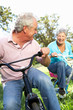 Senior couple playing on children's bikes