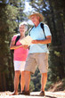 Senior couple reading map on country walk
