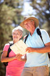 Senior couple reading map on country walk