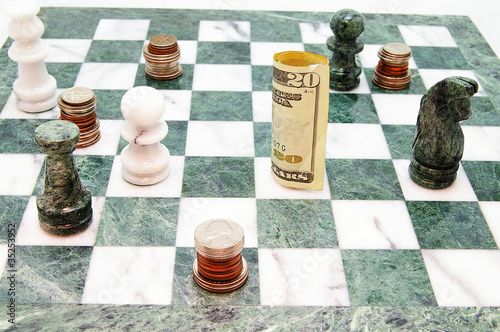 Photo: coins and money on a chess board coins and money on a chess board