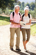 Senior couple reading map on country walk Senior couple reading map on country walk