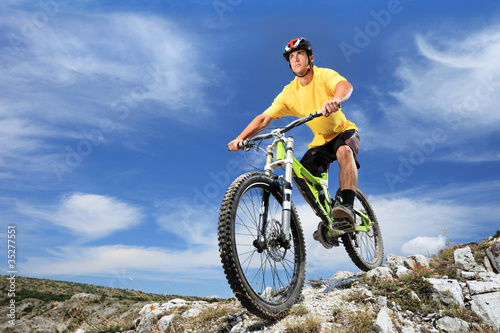 Photo: Young man riding a mountain bike outdoor Young man riding a mountain bike outdoor