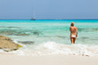 Young woman talking on her mobile / cell phone on the beach.