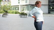 Woman in city with back pain