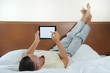 Foto: guy with tablet pc in bed (TW guy with tablet pc in bed (TW