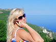 Photo: Woman speaks by a mobile phone Woman speaks by a mobile phone