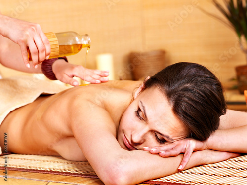 Foto: Woman getting massage in bamboo spa. Woman getting massage in bamboo spa.
