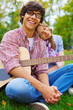 Cheerful teenage couple with guitar in park