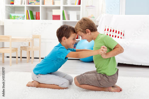 Photo: Two happy boys wrestling Two happy boys wrestling