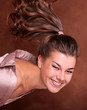 Portrait of a dark-haired smiling girl on a brown background