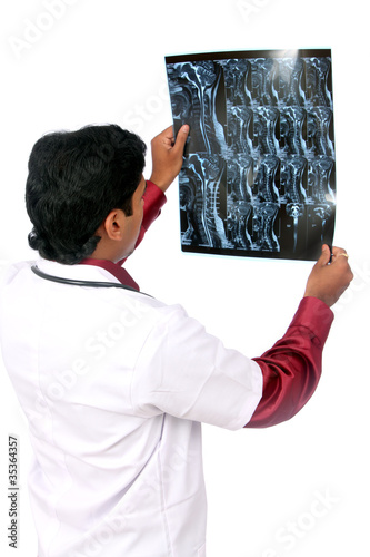 Photo: Doctor examining the X-ray over white. Doctor examining the X-ray over white.